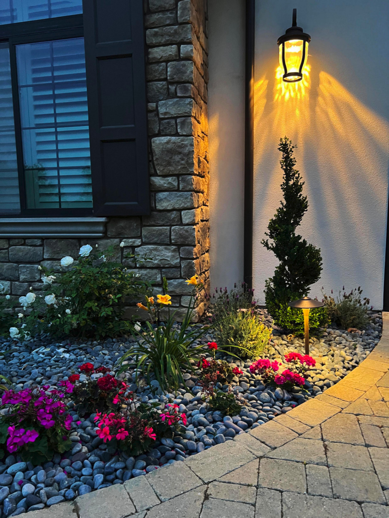 Front yard planting with river rock and warm lantern light